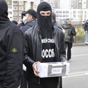 Vermummte Neonazis sammeln am Rande des Marsches Geld für einen Kindergarten